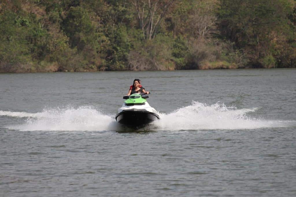 Na Belas Águas Mairiporã uma mulher andando de jet ski no lago perto da pousada.