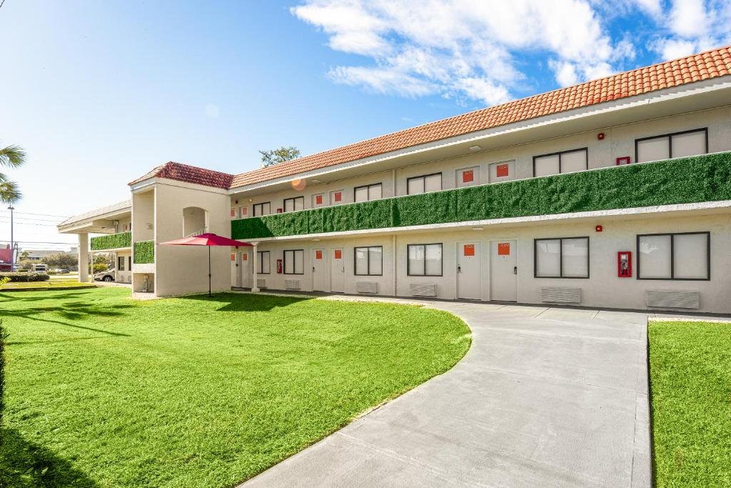 fachada em dois antes com detalhes em verde que parecem grama com janelinhas do Developer Inn Express Fundamental Hotel um dos hotéis em Kissimmee