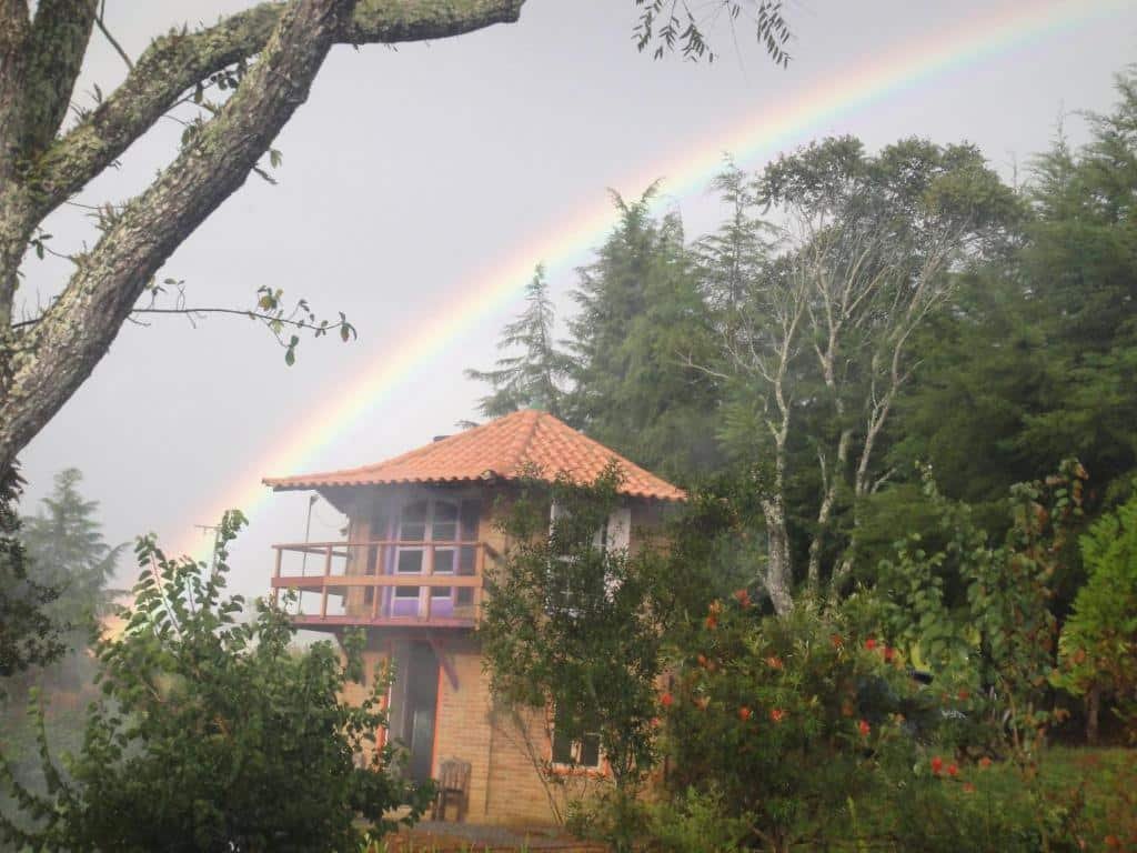 Vista da frete da Pousada Alquimia no meio de arvores em Pousadas em Aiuruoca.
