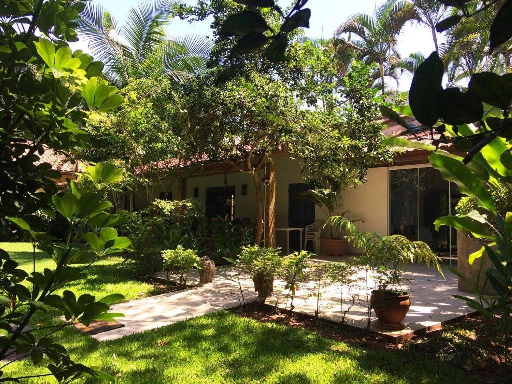 Frente da Juréia Dreams durante o dia com jardim a frente e do lado direito da imagem ao fundo a estadia.