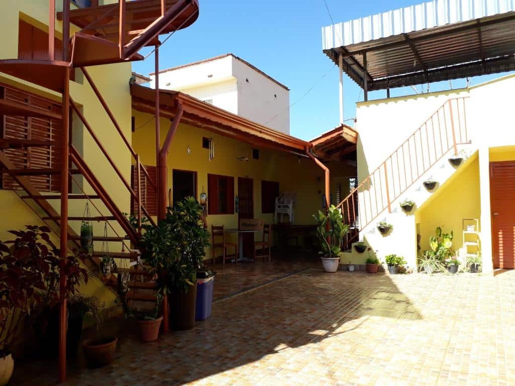 Vista da frente Pousada Recanto das Flores com escada e mesas em Aiuruoca.