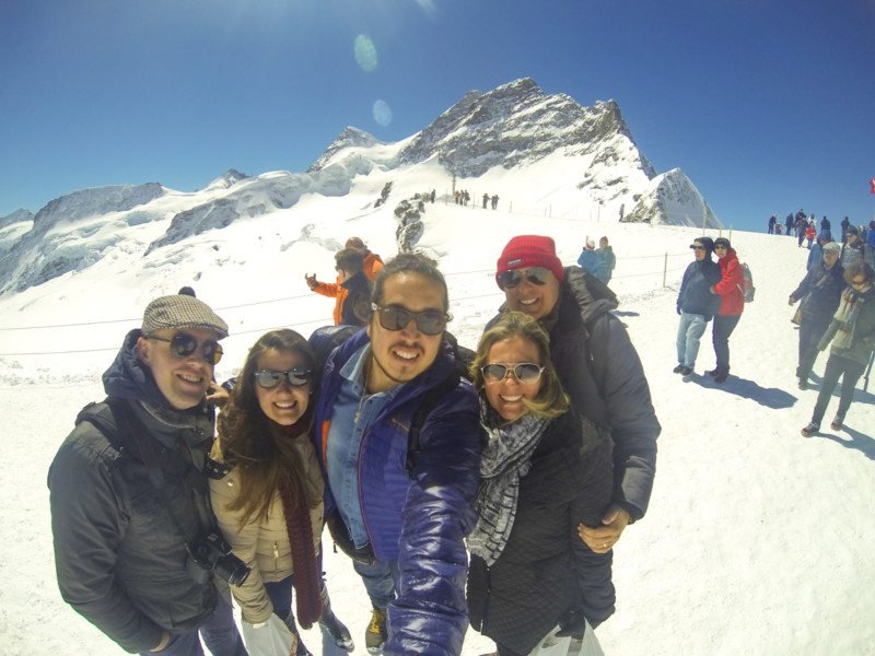 Vários amigos usando roupas de inverno em meio à neve de Jungfrau em Interlaken.