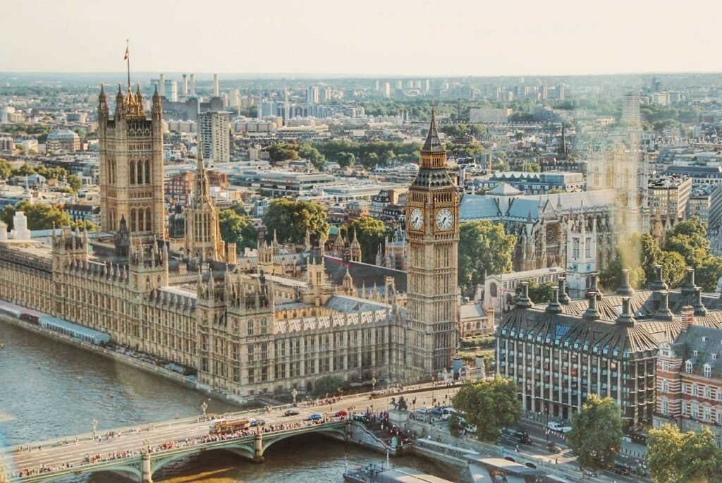 Vista aérea do Palácio de Westminster, às margens do Rio Tâmisa, com a Torre Elizabeth e o horizonte de Londres.