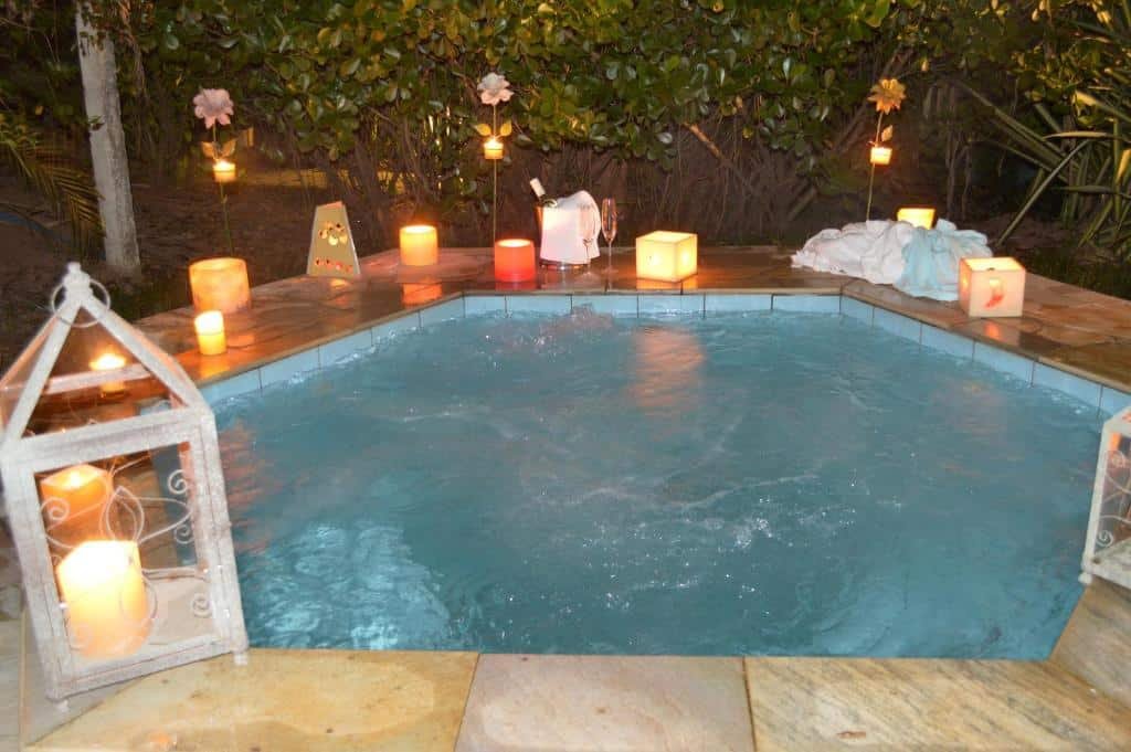 Uma hidro ao ar livre na Pousada da Lua, em São Pedro. Velas estão espalhadas ao redor da sua borda.