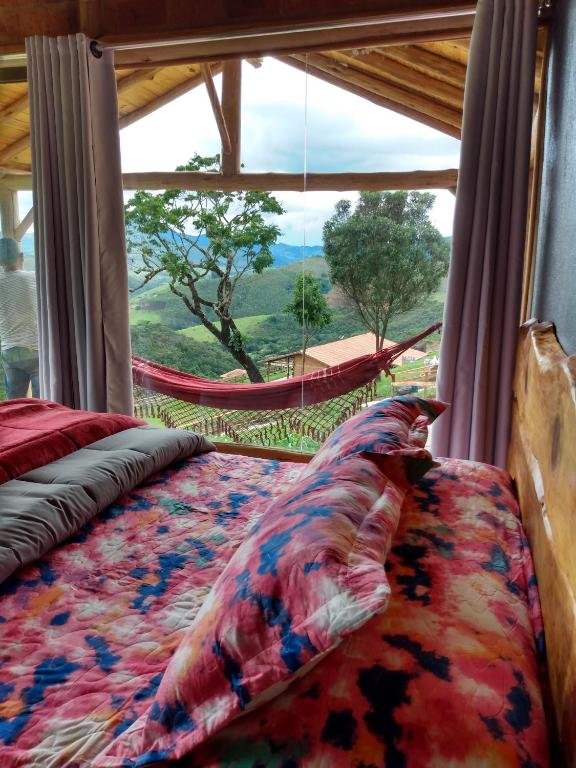 Vista do quarto Recanto das Estrelas com cama e rede .