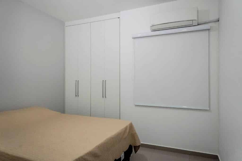 Quarto em Apto Alto Padrão Completo C/ Ar, Piscina e Varanda Gourmet, uma cama de casal, uma armário embutido e um ar-condicionado, para representar pousadas no Centro de Ubatuba