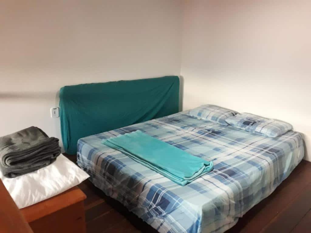 Quarto do airbnb Mi Casa Su Casa Lofts. O colchão está centralizado, no lado esquerdo há outro colchão apoiado na parede e na frente deles há uma mesa com colchas. Imagem para ilustrar o post airbnb em Ilha Grande.