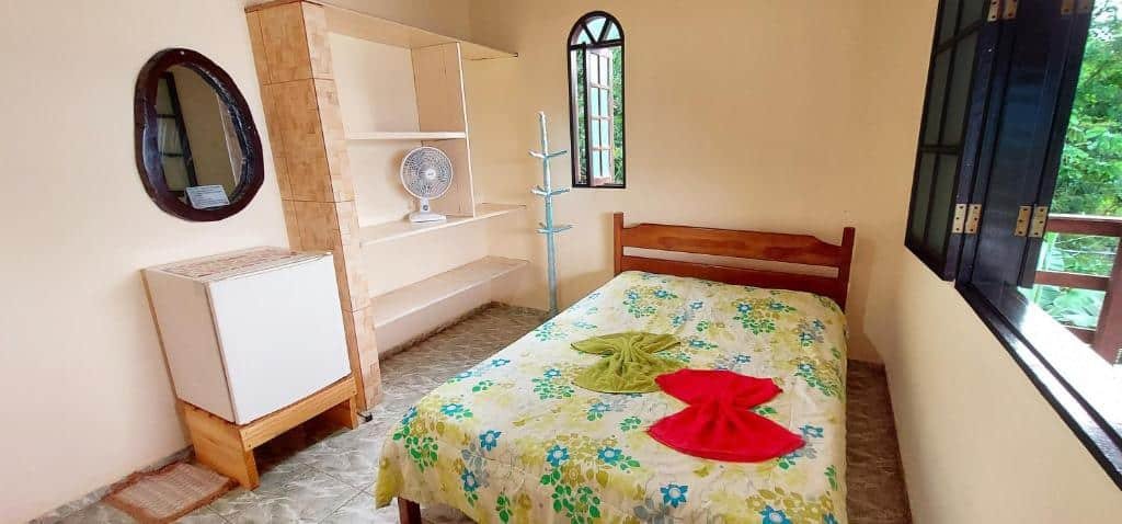 Vista do quarto Pousada Mirante da Chica House com cama, armário e janela.