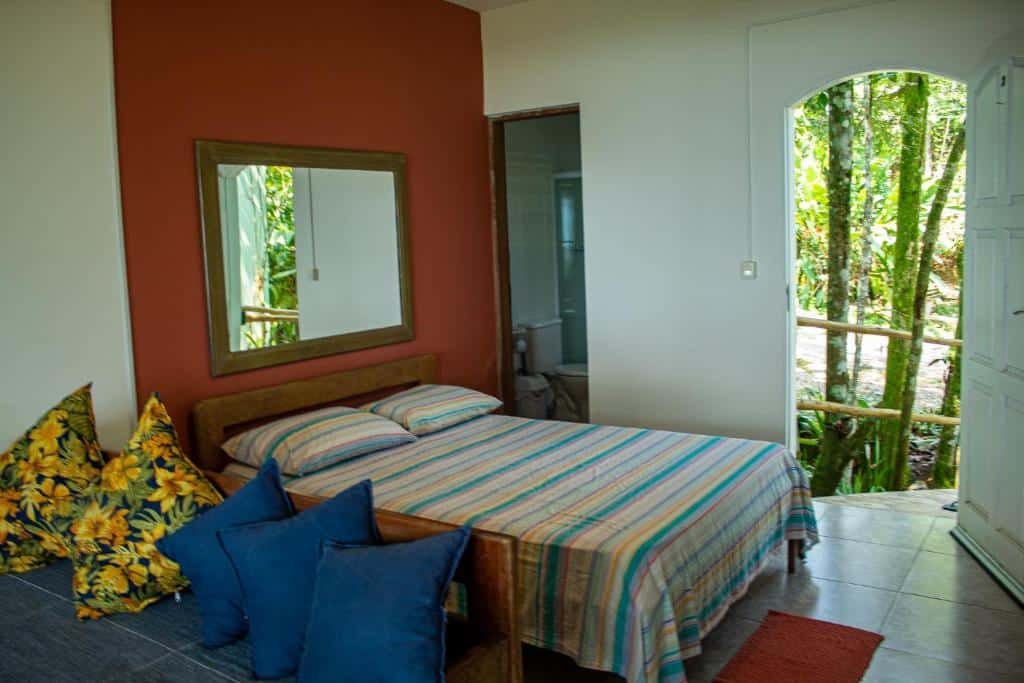 Vista do quarto da Pousada Ubatuba do Alto na Praia da Vermelha do Centro com cama de casal e um sofá.