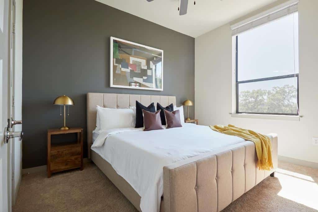 Quarto do Sonder at La Villita com uma cama de casal, ventilador no teto, duas mesinhas pequenas de cabeceira com luminárias e uma janela com persiana do lado direito