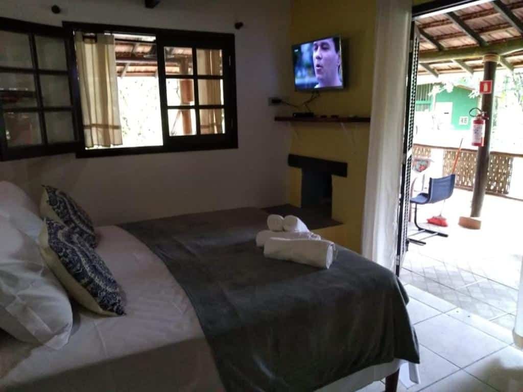 Vista do quarto Pousada Casa Ubatumirim na Praia da Almada com cama e varanda.