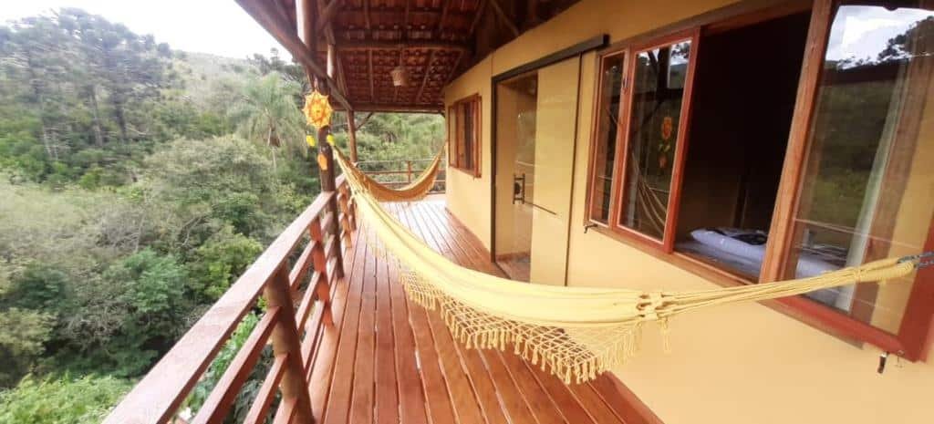 Vista da Pousada Recanto do Ypê  com rede e vista para árvores em Aiuruoca. 